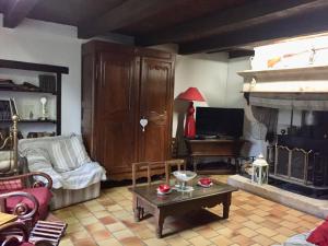 a living room with a couch and a fireplace at Charmante maison historique avec jardin à Vadelaincourt - Charme, cheminée, et sérénité - FR-1-585-67 in Vadelaincourt