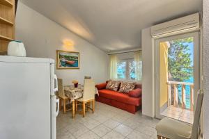 a living room with a red couch and a table at Apartments by the sea Kastel Stafilic, Kastela - 21981 in Kastel Stafilic
