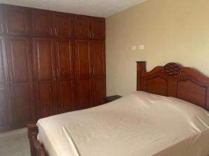 ein Schlafzimmer mit einem großen Bett und Holzschränken in der Unterkunft Quiet space in San Cristóbal