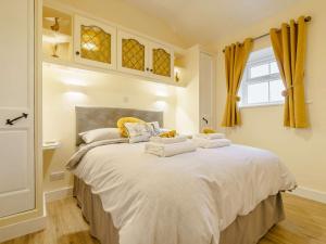 a bedroom with a large white bed with towels on it at 3 Bed in Whitby 90810 in Aislaby