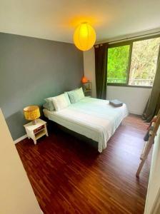 E KOMO MAI في بوناويا: غرفة نوم بسرير كبير مع أرضية خشبية
