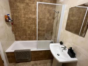 a bathroom with a tub and a sink and a shower at 2 Bedroom Flat in Town Center Wellingborough in Wellingborough