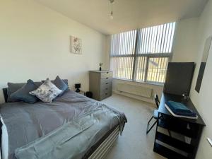 a bedroom with a bed and a desk with a computer at 2 Bedroom Flat in Town Center Wellingborough in Wellingborough