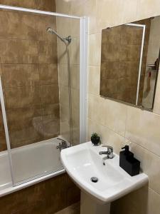 a bathroom with a sink and a shower and a tub at 2 Bedroom Flat in Town Center Wellingborough in Wellingborough