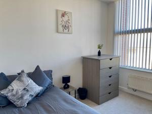 a bedroom with a blue bed and a dresser at 2 Bedroom Flat in Town Center Wellingborough in Wellingborough