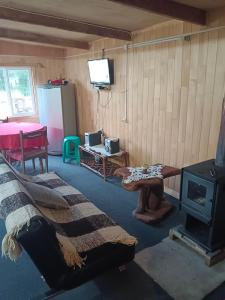 a living room with a bed and a stove at Kataleya in Cochamó