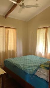 a bedroom with a bed and a ceiling fan at Canopy cottage in Honiara