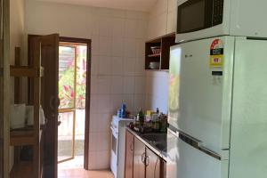 a kitchen with a white refrigerator and a sink at Canopy cottage in Honiara