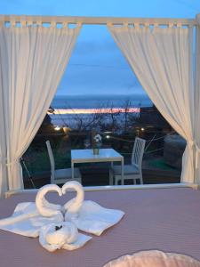 two swan towels on a bed in front of a window at Finca Esferas in La Guancha