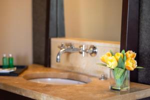 a vase of yellow flowers on a bathroom sink at Villa Physacap in Le François