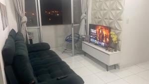 a living room with a couch and a flat screen tv at Apartamento Tupa in Propriá