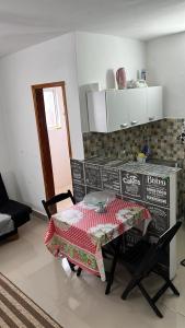 una cocina con mesa en una habitación con mesa Sidx Sidx Sidx Sidx Sidx en Apartamento Itanhanhem en Itanhaém