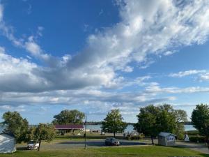 a cloudy sky over a park with a lake at Bavarian Inn in Bruce Mines