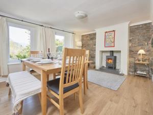 ein Esszimmer mit einem Tisch und einem Kamin in der Unterkunft 4 Bed in Braithwaite SZ533 in Braithwaite