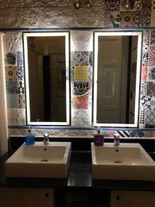 two sinks in a bathroom with two mirrors at Cairo Hub in Cairo