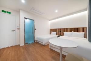 Habitación de hotel con 2 camas y mesa en Hotel gongjicheon 2 en Chuncheon