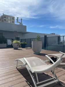 a white chair sitting on top of a wooden deck at Palermo Apartamento Buenos Aires in Buenos Aires