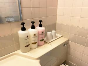 a bathroom with three bottles on the back of a sink at Hotel Royal Oak Gotanda in Tokyo