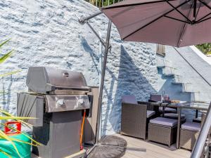 a grill with an umbrella next to a table at 4 Bed in Brixham 77366 in Brixham