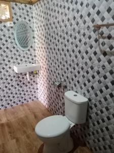 a bathroom with a white toilet and a wall at Visual inn in Toyapakeh