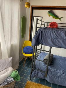 a room with a bunk bed and a yellow chair at Beach Bungalow in Rosarito