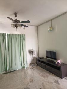 un salon avec un ventilateur de plafond et une télévision dans l'établissement KZ Homestay PD, à Port Dickson