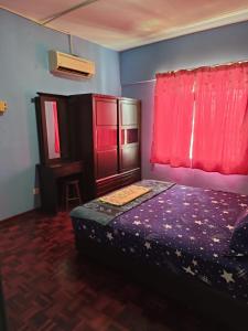 een slaapkamer met een bed en een rood raam bij KZ Homestay PD in Port Dickson