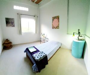 1 dormitorio con cama, mesa y ventana en Pousada Vila da Serra - Quarto Cantinho do Sossego en Nova Lima