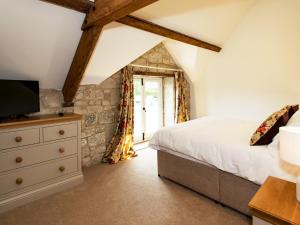 a bedroom with a bed and a dresser with a television at 3 Bed in Melbury Abbas 48804 in Melbury Abbas