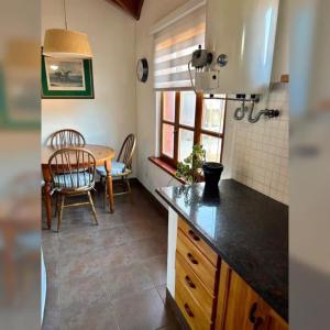 a kitchen with a table and a dining room at Colibrí Tempo in Esquel