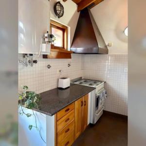 a small kitchen with a stove and a sink at Colibrí Tempo in Esquel