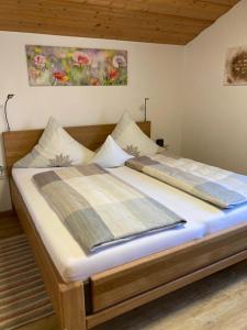 1 dormitorio con 1 cama grande con marco de madera en Schneiderhof Urlaub auf dem Bauernhof en Bernau am Chiemsee