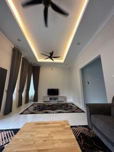 a living room with a ceiling fan and a couch at D’Asam Homestay Baling in Baling