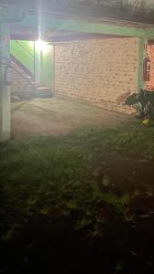 um quintal à noite com uma parede de tijolos em Motel Casarão em Osório