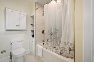 a bathroom with a toilet and a shower curtain at Spacious & Cozy Home in Highfield St Moncton in Moncton