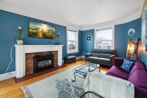 a living room with a purple couch and a fireplace at Spacious & Cozy Home in Highfield St Moncton in Moncton