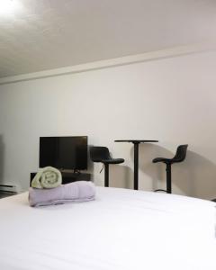 a bedroom with a bed with two chairs and a flat screen tv at Cozy studio apartment - 240 in Montreal