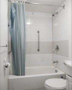 a bathroom with a tub and a toilet and a shower at Cozy studio apartment - 240 in Montreal