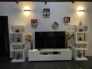 a large white entertainment center with a flat screen tv at MOOREA - Villa Tiahura in Hauru