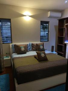 um quarto com uma cama com almofadas em MOOREA - Villa Tiahura em Hauru