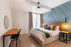 a bedroom with a bed and a desk in it at Ocean Villa in Durban