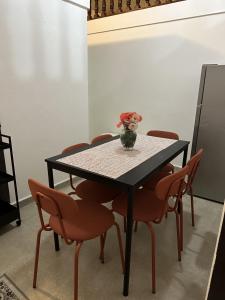 a table with chairs and a vase of flowers on it at 176 Calle Perez (Apt 1A) in San Juan