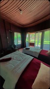 two beds in a bedroom with a wooden ceiling at Raflow Resort Raja Ampat in Tapokreng