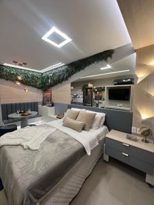 ein Schlafzimmer mit einem großen Bett und eine Küche in der Unterkunft Flat Super Luxo - Boa Viagem in Recife