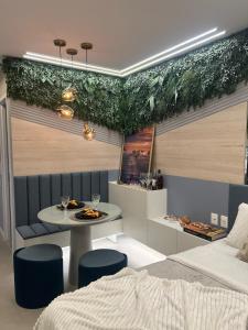 ein Schlafzimmer mit einem Bett, einem Tisch und Stühlen in der Unterkunft Flat Super Luxo - Boa Viagem in Recife