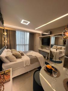 ein Schlafzimmer mit einem großen Bett und einem Tisch in der Unterkunft Flat Super Luxo - Boa Viagem in Recife