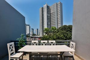 a table and chairs on a balcony with tall buildings at Ocean Villa in Durban