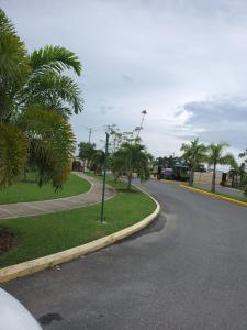 an empty street with palm trees on the side of the road at Finest Accommodation #528 Stem Ave Jacaranda 1 bedroom in Spanish Town