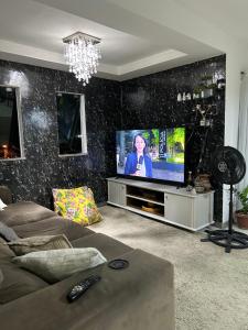 sala de estar con sofá y TV en Residencial EL - shadai, en Porto Seguro