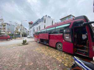 un autobus rosso parcheggiato sul lato di una strada di ANH ĐÀO HOTEL LẠNG SƠN a Lạng Sơn